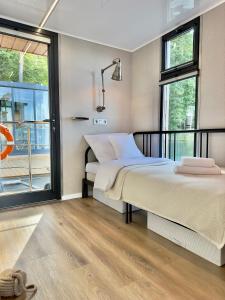吉日茨科Domki na wodzie - Resort 36 Houseboats的一间带两张床的卧室和一个阳台
