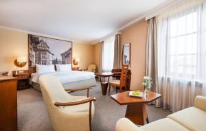 布拉格Lindner Hotel Prague Castle, part of JdV by Hyatt的酒店客房带一张床、一张桌子和椅子