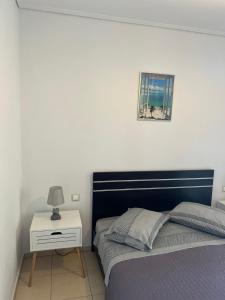 阿特米达Luxury Studio Artemida的卧室配有一张床,墙上挂着一幅画