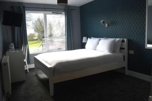 阿布罗斯Lunan House的一间卧室配有一张带窗户的床和一张四柱床