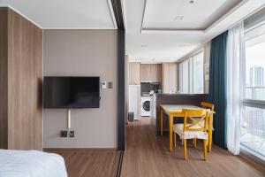 釜山Flat nearby Heaundae beach的酒店客房设有床、桌子和电视。