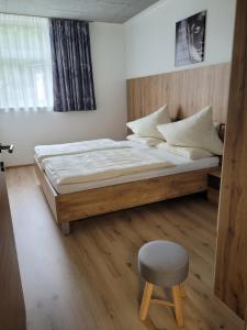 米尔施塔特Lucashof Millstättersee的一间卧室配有一张大床和一把椅子