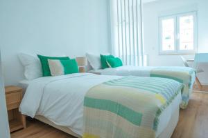卡尔卡维洛斯NEW Estrela da Praceta Apt w/ 3 Suites & Oceanview的一间卧室配有两张绿色和白色的床