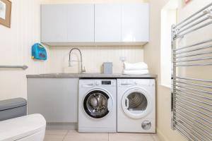 邓布兰Cauldhame House的厨房配有洗衣机和水槽