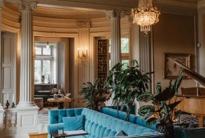 胡斯克瓦纳Hotel Slottsvillan的客厅配有蓝色的沙发和吊灯。