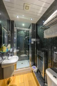 雷德卡Abbey Guest House的带淋浴、盥洗盆和浴缸的浴室