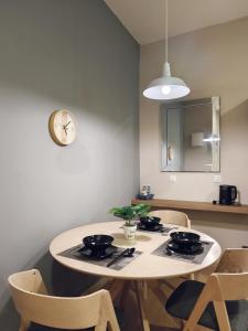 关丹Valley Suites by WyattHomes的餐桌、椅子和墙上的时钟