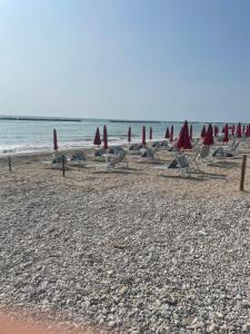 MassignanoResidence Verde Mare的海滩上的一组椅子和遮阳伞