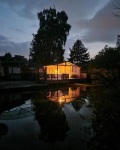 赫尔Rustig gelegen chalet Solvo met terras aan het water的夜空在水体旁的房屋