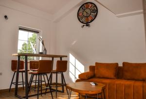 诺维·维诺多尔斯基Apartman Nada的带沙发、桌子和时钟的客厅