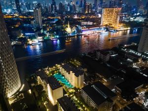 曼谷The Quarter Chaophraya by UHG的城市天际线,夜晚有河流和建筑