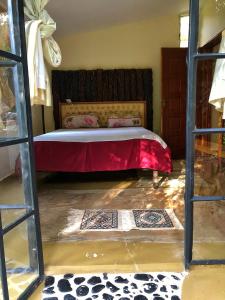 纳纽基The Murana Chalet的一间卧室配有一张带红色毯子的床