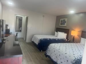 萨拉索塔Flamingo Inn的酒店客房设有两张床和盥洗盆