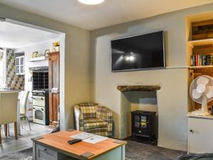 多尔顿因弗内斯Beeswax Cottage的客厅的墙上配有平面电视。