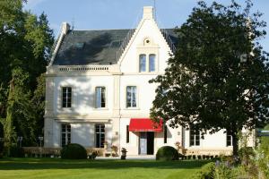勒比松德卡多恩贝勒里夫庄园酒店的一座白色的大房子,有红色遮阳篷
