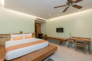 蔻立Khaolak Wanaburee Resort - SHA Extra Plus的一间卧室配有一张床、一张桌子和吊扇