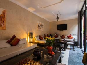 马拉喀什橙色乐贝儿庭院旅馆的客厅配有沙发和桌子