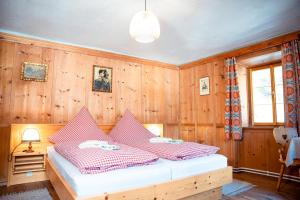 埃尔比格纳尔普Landhaus Geierwally的卧室设有木墙和一张红白色床单。