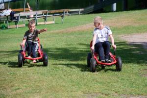 兰伯尔瑞德伯达尔露营酒店的两个男孩在草地上骑玩具车