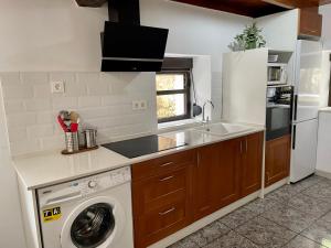 里瓦德塞利亚Casa Mariyina的厨房配有洗衣机和水槽