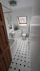 拜伯里Cotteswold House的浴室配有卫生间、盥洗盆和浴缸。