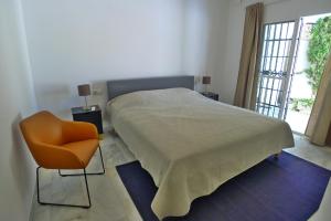 内尔哈Villa Golondrinas - Private villa to sleep 6的卧室配有床、椅子和窗户。