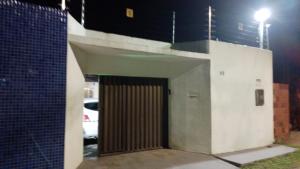 阿拉卡茹CASA DE TEMPORADA RECANTO FELIz 2的通往大楼的大门,晚上有停车位