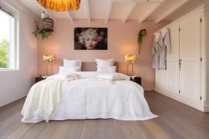 赞德沃特瓦可胡赛迪泽帕瑞度假屋的卧室配有白色床单和白色大床