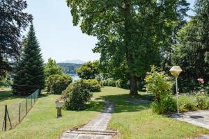 沃尔特湖畔韦尔登Villa Fernblick的一条穿过花园的小径,花园的后面是湖泊