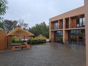 马塞卢Jate Guest House的一座带长凳和稻草伞的建筑