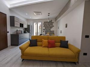 托尔托利Santeria Modern Loft的客厅设有一张黄色沙发,配有厨房