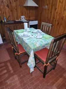 卢汉德库约La cabaña de Tito.的一张桌子,上面有一张桌子布,上面有两把椅子