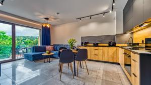 斯克拉斯卡波伦巴Apartamenty z basenem i saunami ROYAL APARTS VIP Stone Hill Centrum的厨房以及带沙发和桌子的客厅。