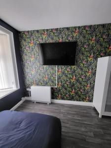 莱斯特City Centre Studios 3的卧室配有一张床,墙上配有电视。
