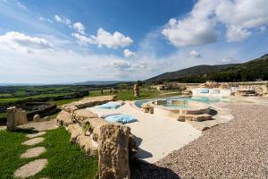 GergeiIs Perdas Rural Retreat & Spa的山坡旁的游泳池,设有岩石挡墙
