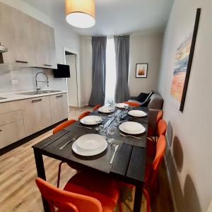 都灵Casa Sobit的餐桌、橙色椅子和厨房