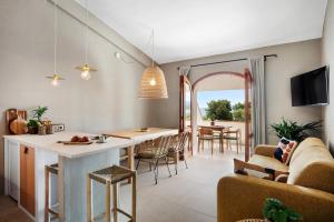 Porto IstanaBaia Dorata beach apartment的厨房以及带桌椅的起居室。