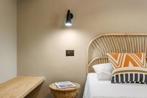 Porto IstanaBaia Dorata beach apartment的一间卧室配有一张带木制床头板和一张桌子的床。