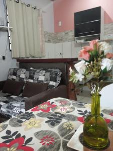 戈亚斯州上帕莱索Chalés Alto Da Estância的客厅配有带花瓶的桌子