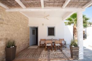 VathíTERRA E SOLE spa suite Aegina的一个带桌椅和天花板的庭院