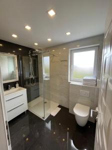 马卡尔斯卡Luxury apartment in Hotel的带淋浴、卫生间和盥洗盆的浴室