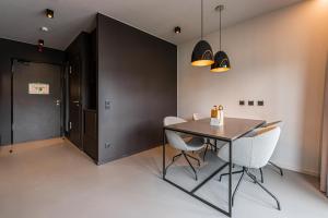 莱比锡YUMA Apartments Leipzig Berliner Straße的一间带桌子和白色椅子的用餐室