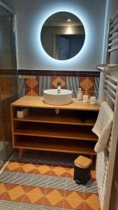 圣皮索内维尔Hotel Trinquet的一间带水槽和镜子的浴室
