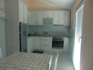 蒂瓦特Apartment Villa Dobrijevic -Seljanovo的厨房配有白色橱柜和桌子