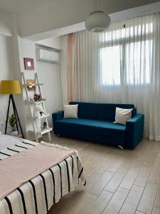 都拉斯Lola’s Apartment的客厅设有蓝色的沙发和窗户。