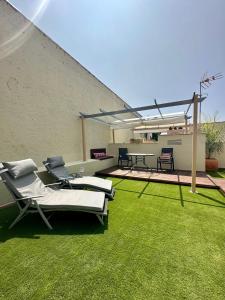马拉加La Casa de la Alameda的一座带草坪椅和桌子的庭院