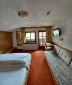 皮茨河谷圣莱昂哈德Hotel Restaurant Liesele Sonne的酒店客房,设有两张床和一张沙发