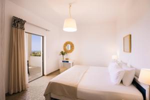 普拉基亚斯Villa Stella Suites的一间白色卧室,配有床和阳台
