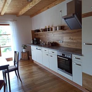 普夫龙滕Ferienwohnung Morgenrot的厨房配有白色橱柜和炉灶烤箱。