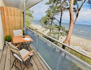卢布明Apartment "OCEANVIEW"的一个带桌椅和海滩的阳台